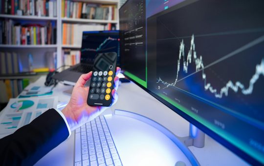 A modern office desk setup with financial analysis tools, highlighting technology in business strategy.